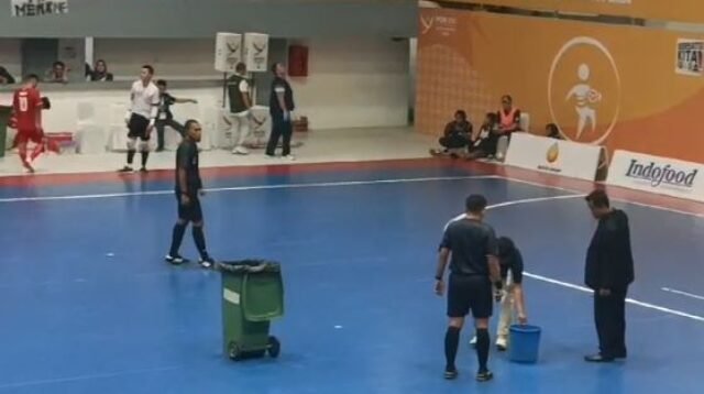 Para Wasit tampak sedang menampungair hujan yang masuk ke GOR Futsal Jalan Pancing karena atapnya bocor.