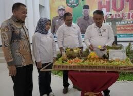 Basarin Yunus Tanjung potong  tumpeng diacara peringatan HUT Koperasi ke-77. 