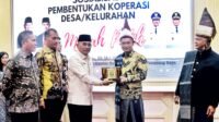 Bupati Simalungun saat memberikan pemberian cenderamata berupa plakat Habonaron Do Bona kepada Deputi Bidang Kelembagaan dan Digitalisasi Koperasi Kemenkop RI.