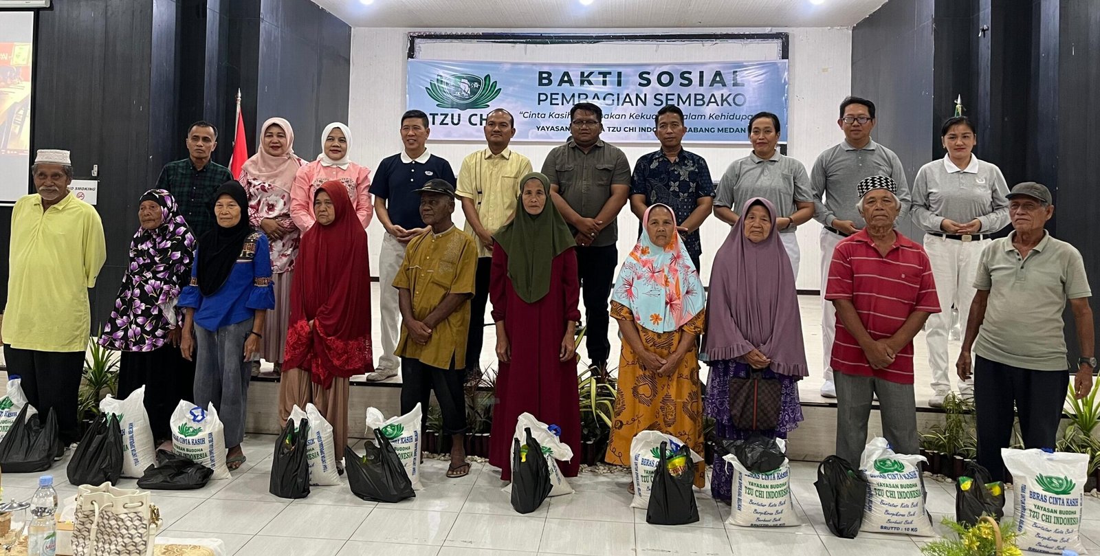 Mahyaruddin bersama pengurus Yayasan Budha Tzu Chi, foto bersama penerima paket sembako.