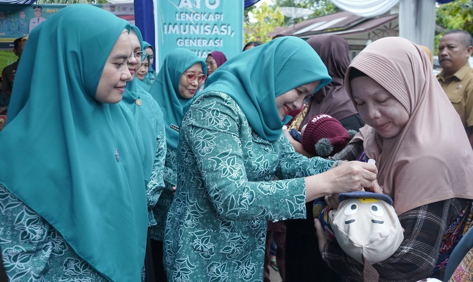 Ketua TP PKK Asahan Ny Yusnila Indriati Taufik lakuin imunisasi terhadap salah seorang balita