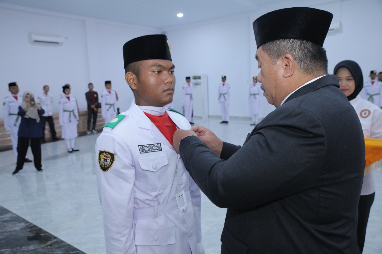 Taufik Zainal Abidin secara simbolis sematkan Lencana Latihan Kepemimpinan Perintis Pemuda kepada pemimpin upacara"