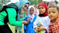 Ketua TP PKK Simalungun sekaligus Bunda PAUD, Ny. Darmawati Anton Achmad Saragih saat serahkan kartu Identitas kepada siswa-siswi.
