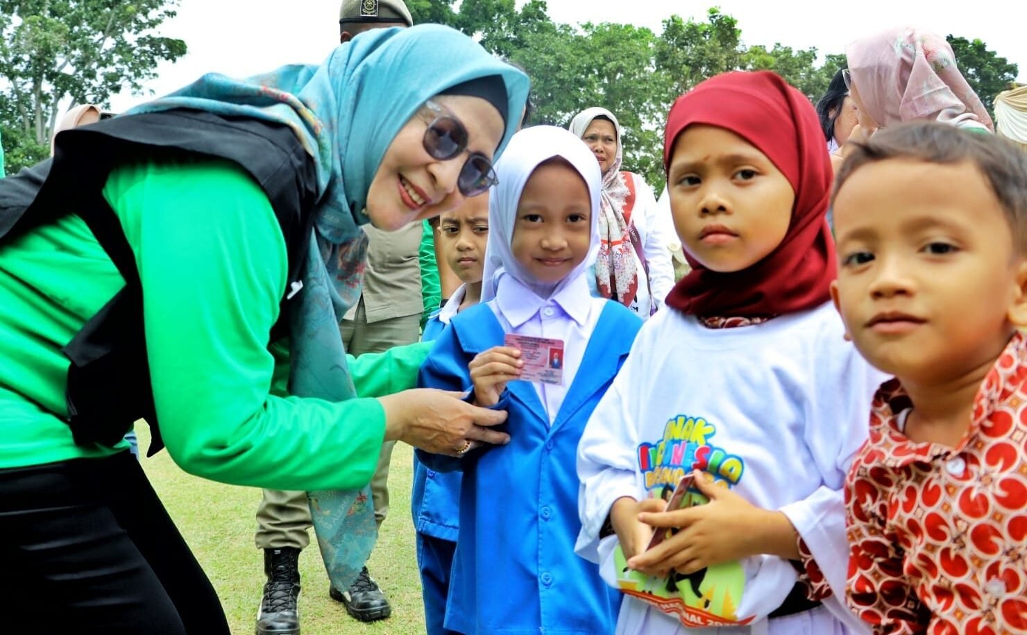 Ketua TP PKK Simalungun sekaligus Bunda PAUD, Ny. Darmawati Anton Achmad Saragih saat serahkan kartu Identitas kepada siswa-siswi.
