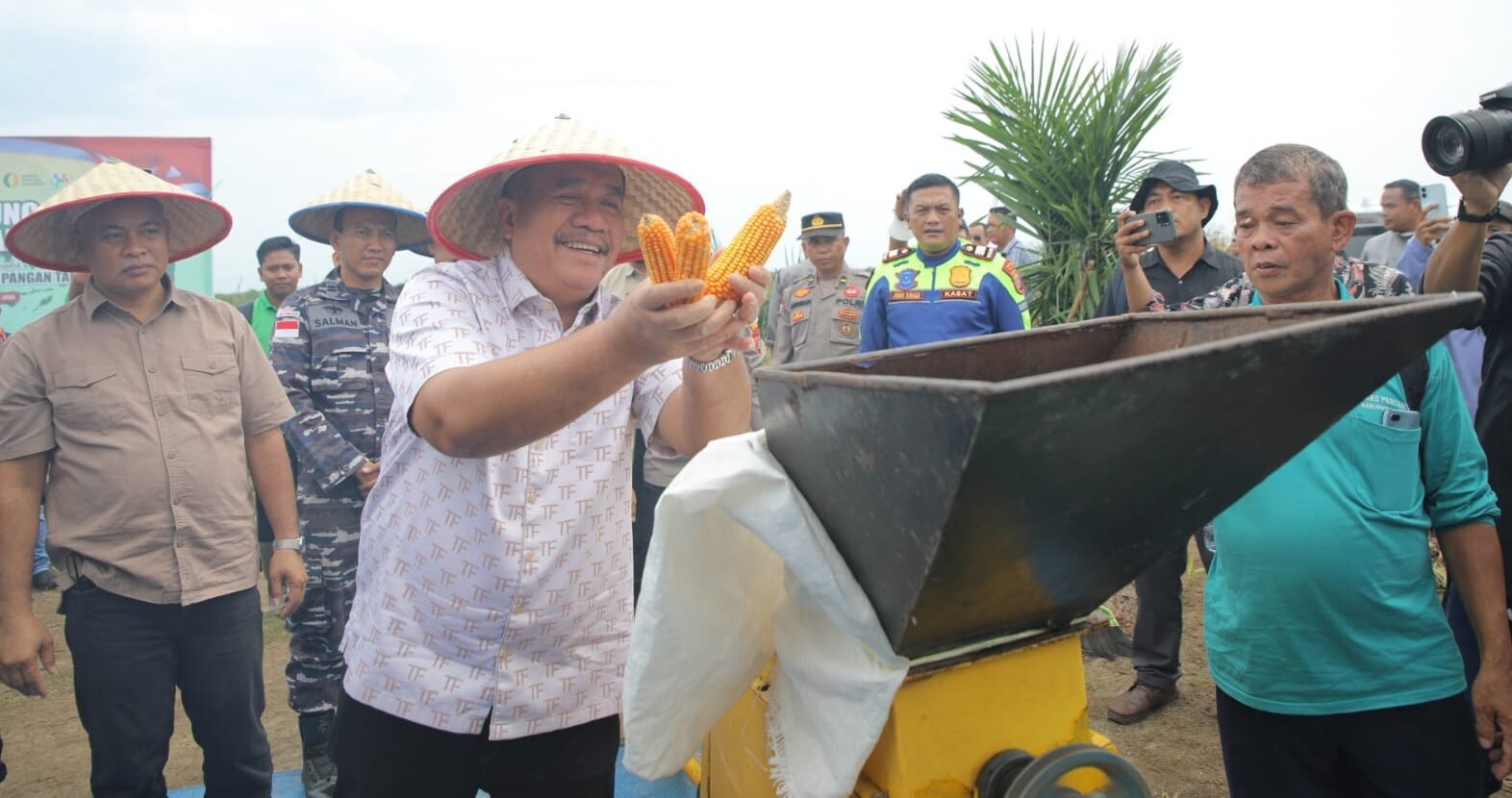 Bupati Asahan Taufik Zainal Abidin masukkan jagung ke mesin giling pemecah jagung.