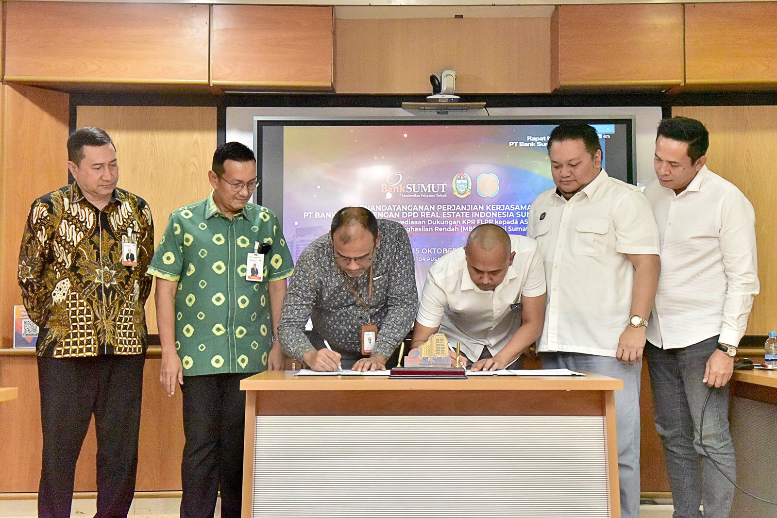 Direktur Bisnis dan Syariah Bank Sumut, Syafrizalsyah menyaksikan acara penandatangan perjanjian kerja sama PT Bank Sumut DPD Real Estate Indonesia (REI) Sumut, terkait Program Penyediaan Dukungan KPR FLPP kepada Masyarakat Berpenghasil Rendah (MBR) yang ada di Provinsi Sumut. Penandatangan tersebut dilaksanakan di Gedung Kantor Pusat Bank Sumut, Jalan Imam Bonjol Medan