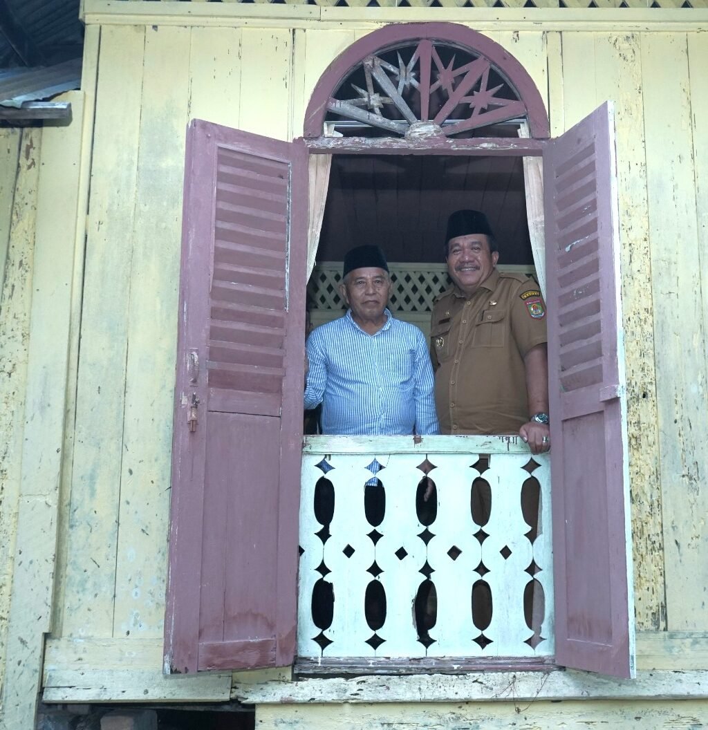 Taufik Zainal Abidin tinjau dari balik jendela Rumah Musyawarah/Mufakat dan Masjid MTQ 1946.