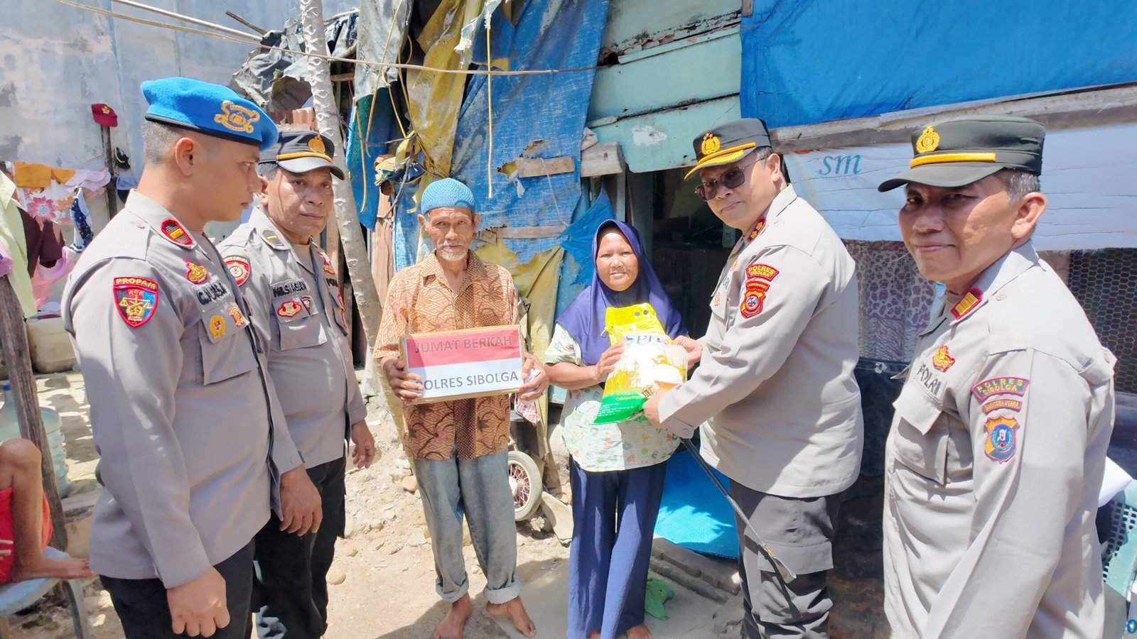 Kapolres Sibolga AKBP Eddy Inganta, S.H., S. I. k.,. M.H saat menyerahkan bantuan kepada salah satu warga yang kurang mampu pada Jumat Berkah, Jumat (14/11/2025).