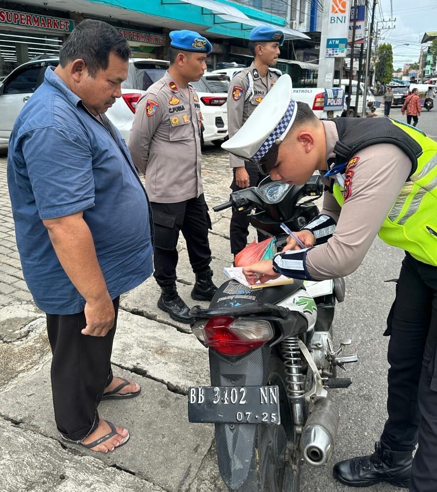 Personil Satlantas Polres Sibolga saat menilang pengendara roda dua yang tidak memakai helm diJalan SM. Raja Sibolga, Selasa (20/11/2025).