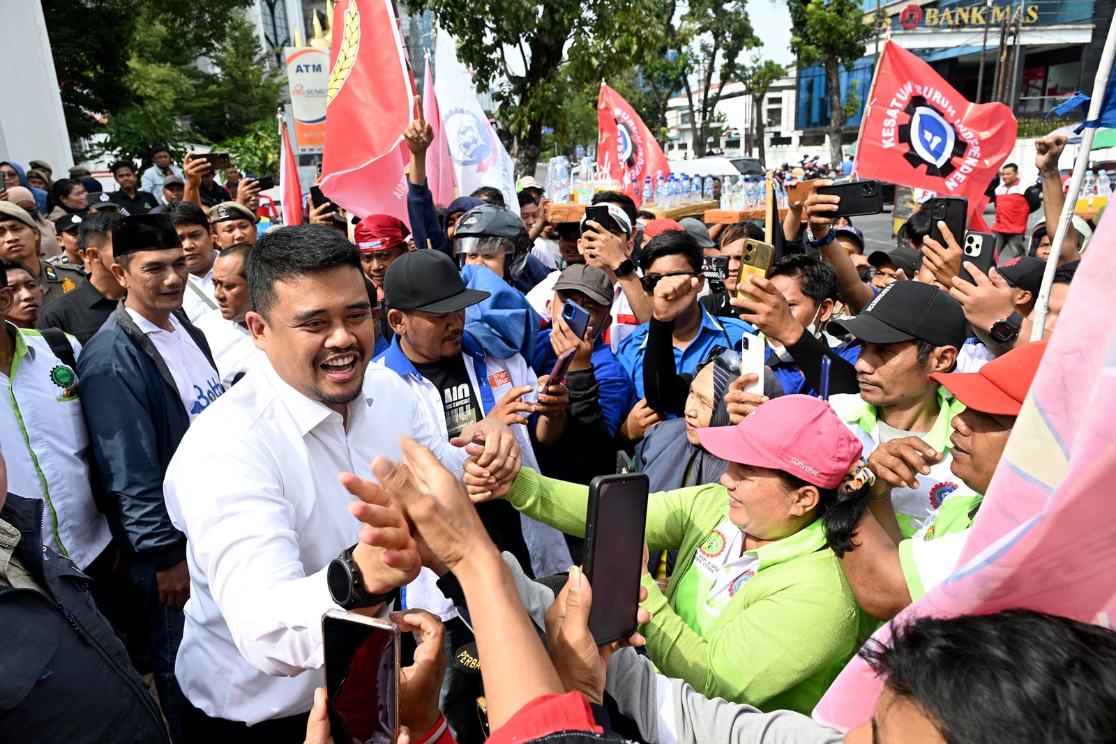 Gubernur Sumatera Utara (Sumut) Muhammad Bobby Afif Nasution didampigi Pj Sekdaprovsu Sulaiman Harahap, Asisten Administrasi Umum Muhammad Suib, serta Kadis Tenaga Kerja Sumut Yulia Siregar, menemui para buruh yang demonstrasi meminta kenaikan upah minimum sebesar 10% di depan Kantor Gubenur Sumut Jalan Diponegoro 30 Medan