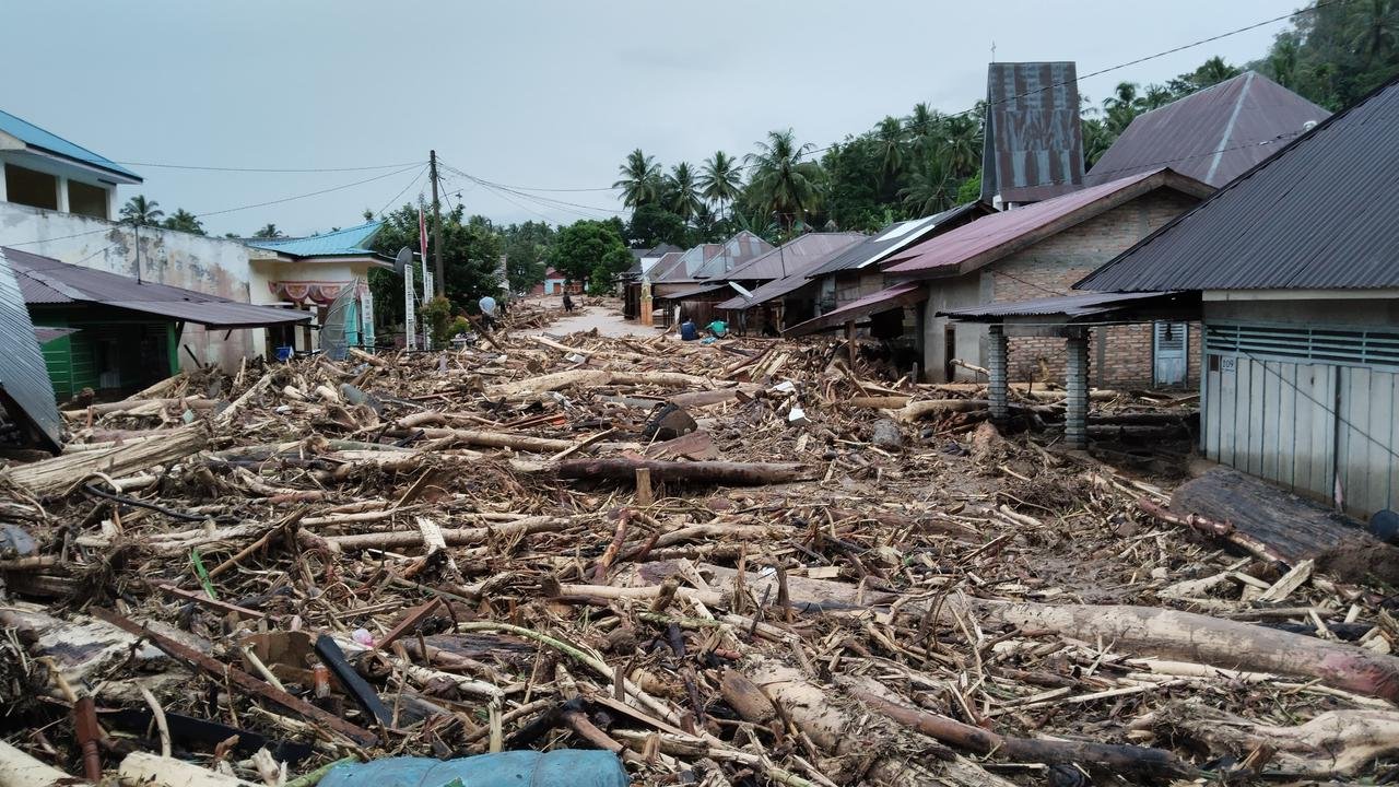 Suasana Banjir yang dipenuhi kayu gelondongan