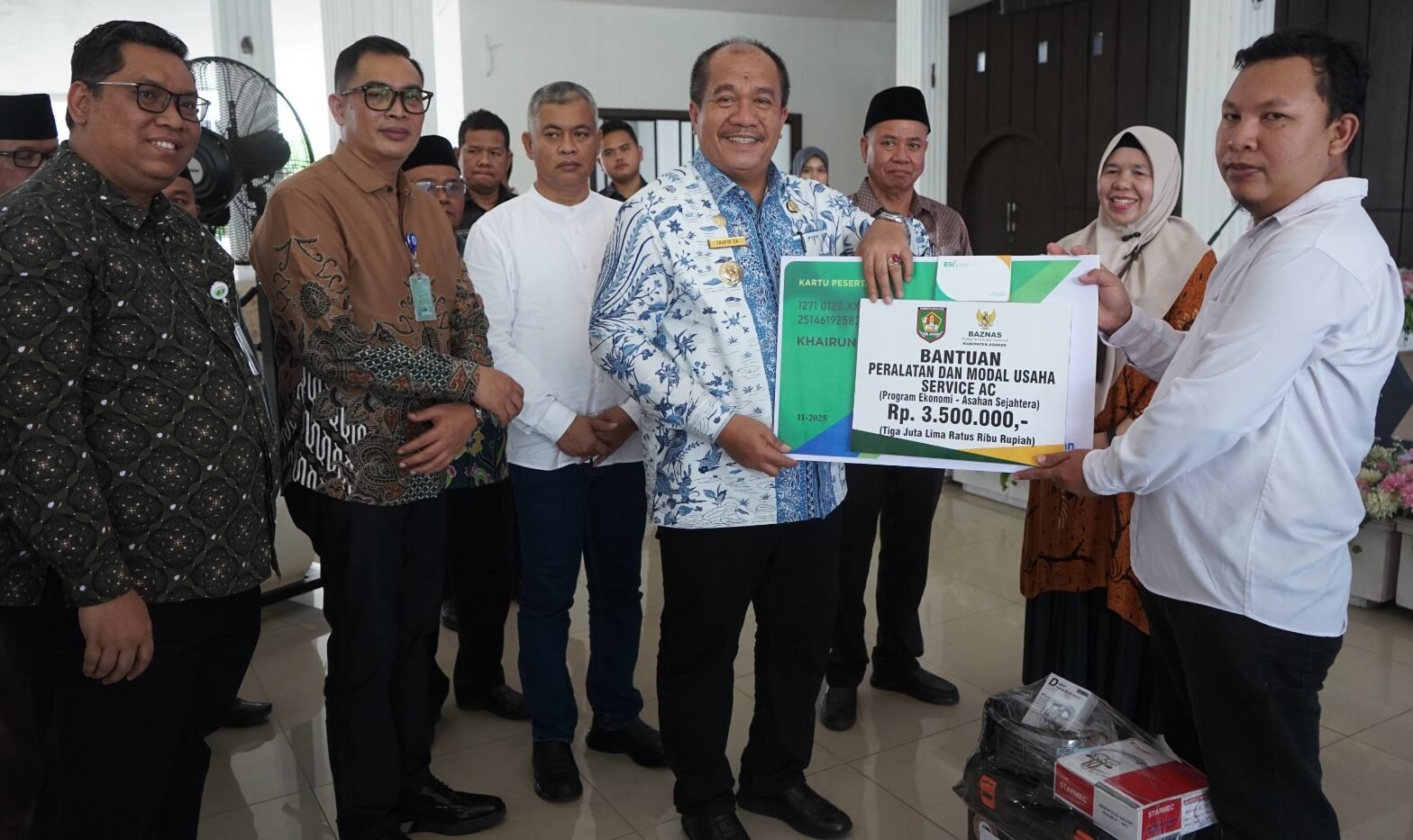 Bupati Asahan Taufik Zainal Abidin serahkan bantuan modal secara simbolis kepada salah seorang peserta pelatihan.