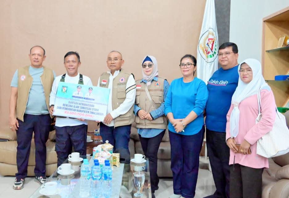 Bupati Tapteng Masinton Pasaribu, SH, MH saat menerima bantuan uang secara simbolis dari Bupati Simalungun Dr. H. Anton Achmad Saragih di ruang kerja Bupati Tapteng, Minggu (7/12/2023).