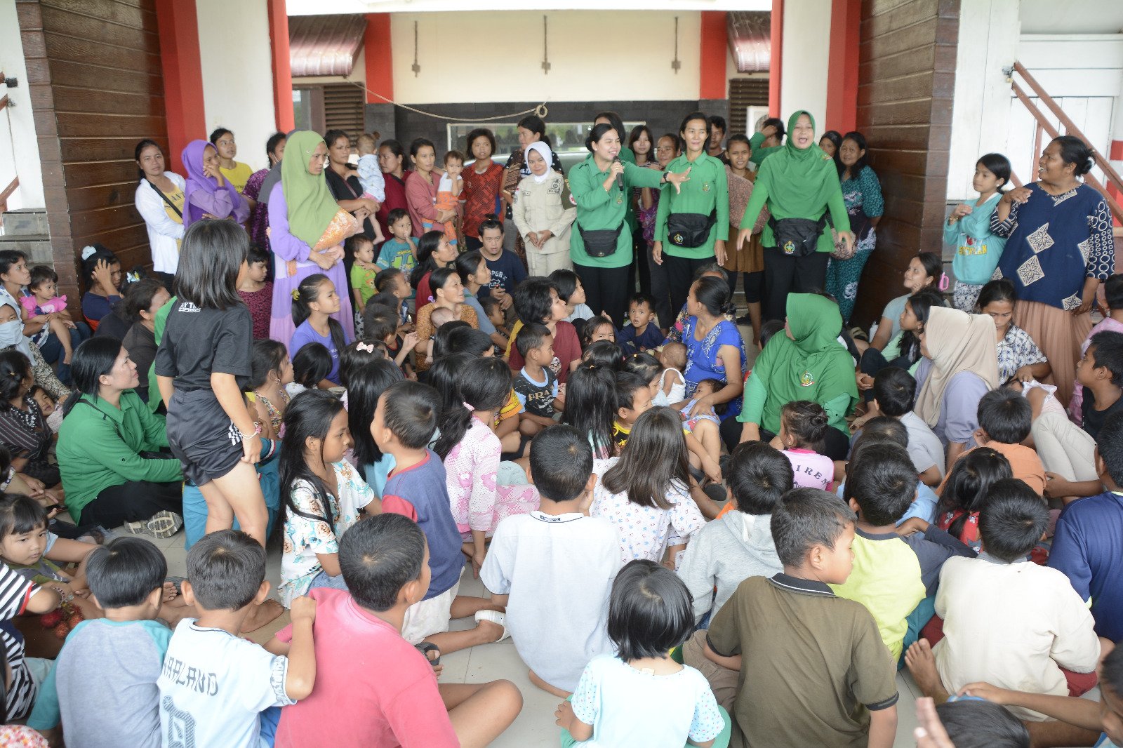 Persit Korem 023/KS saat melakukan kegiatan trauma healing pada anak-anak pengungsi bencana di GOR Pandan, Sabtu (13/12/2025).
