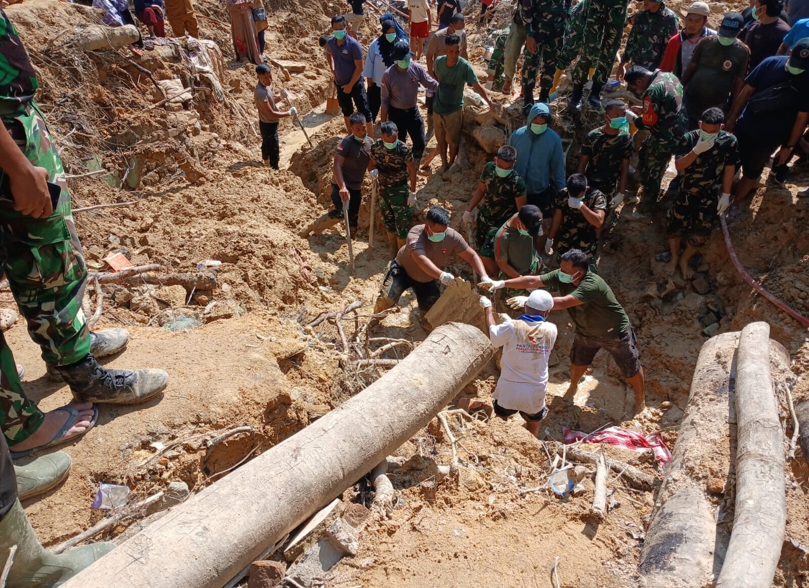 Personil Polres Sibolga bersama Tim gabungan saat berhasil menemukan korban yang tertimpa longsor di belakang Masjid Budi Sehati, Kelurahan Pancuran Gerobak, Kota Sibolga, Selasa (23/12/2025).