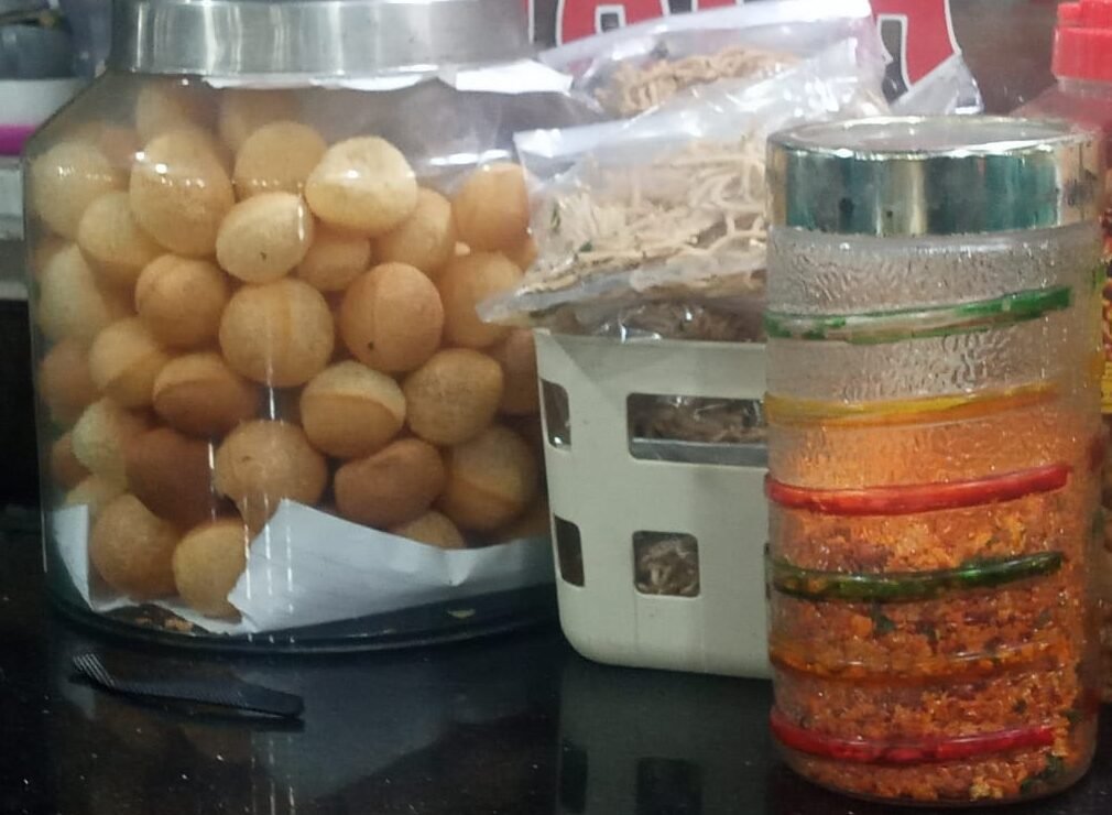 Di stan kuliner Sahara Indian Food. Bahan makanan untuk membuat panipuri siap saji tampak steril di simpan di dalam toples kaca besar tertutup.