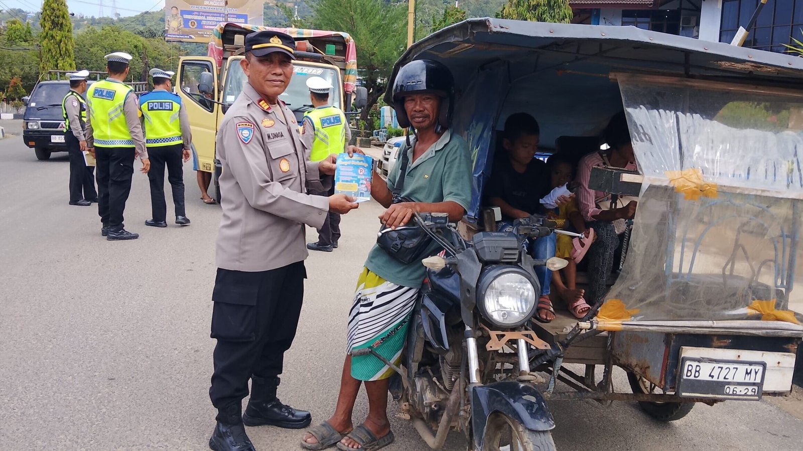 Personel Polres Sibolga saat membagikan brosur himbauan keselamatan berlalu lintas kepada pengendara kendaraan di jalan raya, Rabu (04/02/2026).