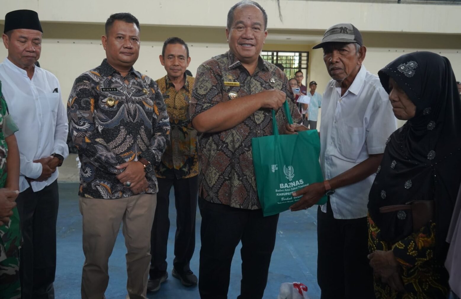 Bupati Asahan Taufik Zainal Abidin menyerahkan secara simbolis paket bantuan sembako kepada salah seorang perwakilan masyarakat