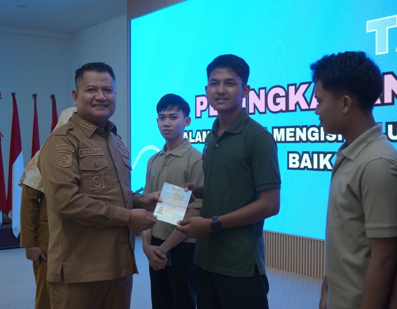 Salah seorang pencari kerja menerima Paspor dari Wakil Bupati Asahan Rianto.