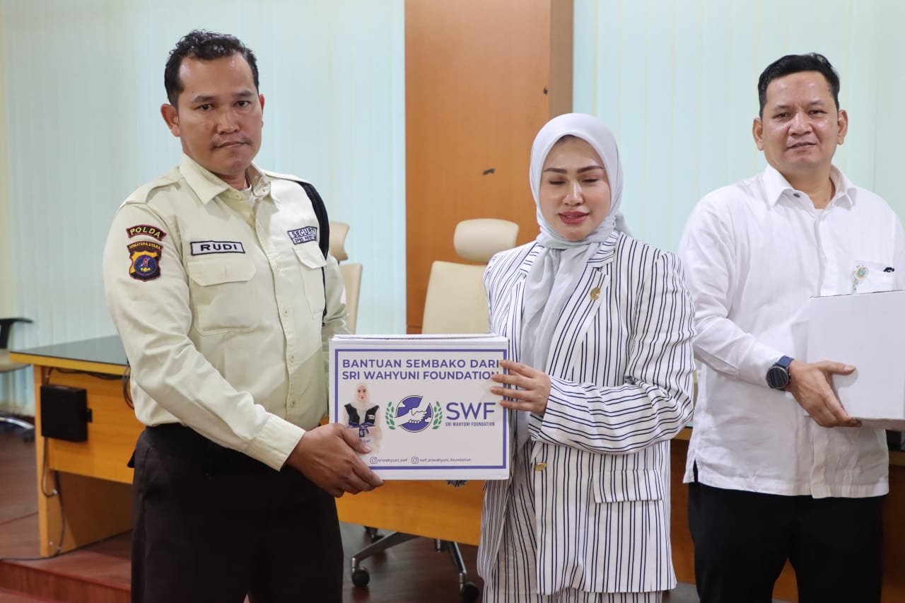 Ketua DPRD Sumatera Utara Sumut Erni Ariyanti, SH, MKn di di dampingi Sekwan DPRD Sumut Ali Sipahutar, SSTP, MAP menyerahkan bantuan paket sembako dari Sri Wahyuni Foundation kepada Rudi, perwakilan Satpam DPRD Sumut.