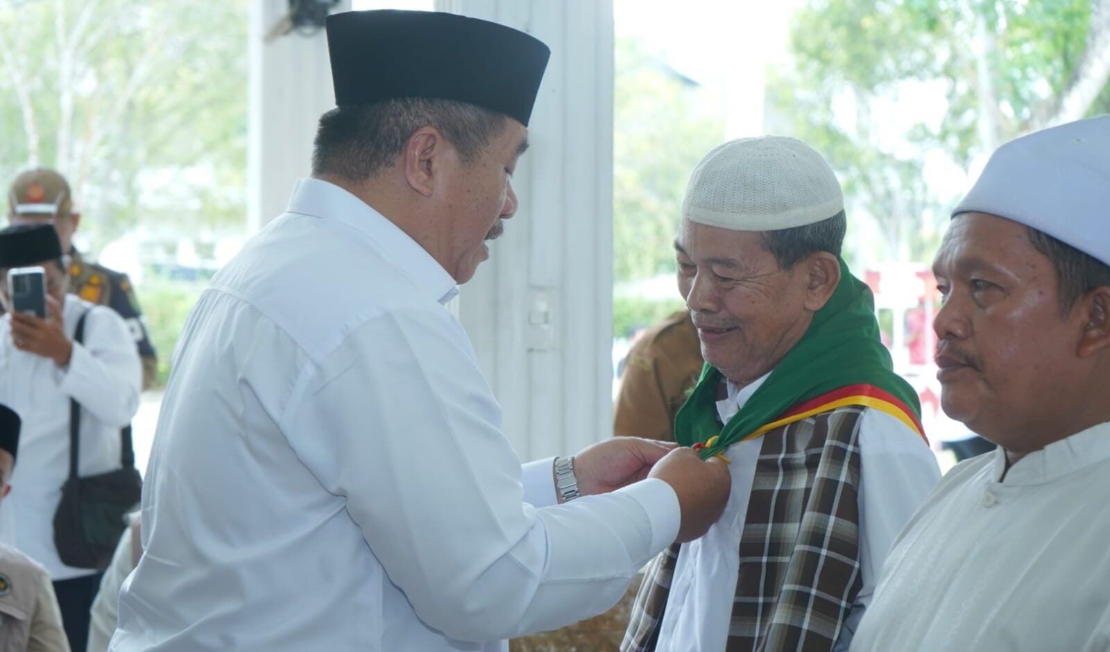 Bupati Asahan Taufik Zainal Abidin pakaikan syal secara simbolis kepada Calon Jamaah Haji.