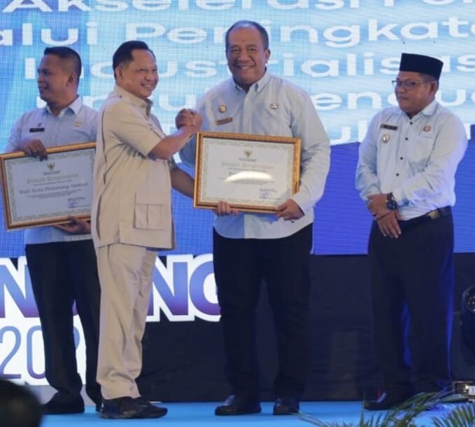 Muhammad Tito Karnavian saat menyerahkan piagam penghargaan kepada Bupati Asahan Taufik Zainal Abidin.