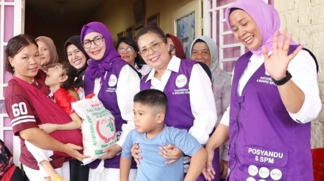 Ny. Hj. Darmawati Anton Achmad Saragih serahkan paket sembako.