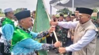 Bupati Simalungun saat penyerahan pataka Habonaron Do Bona kepada ketua rombongan sebagai doa restu agar perjalanan jamaah selamat dan lancar.