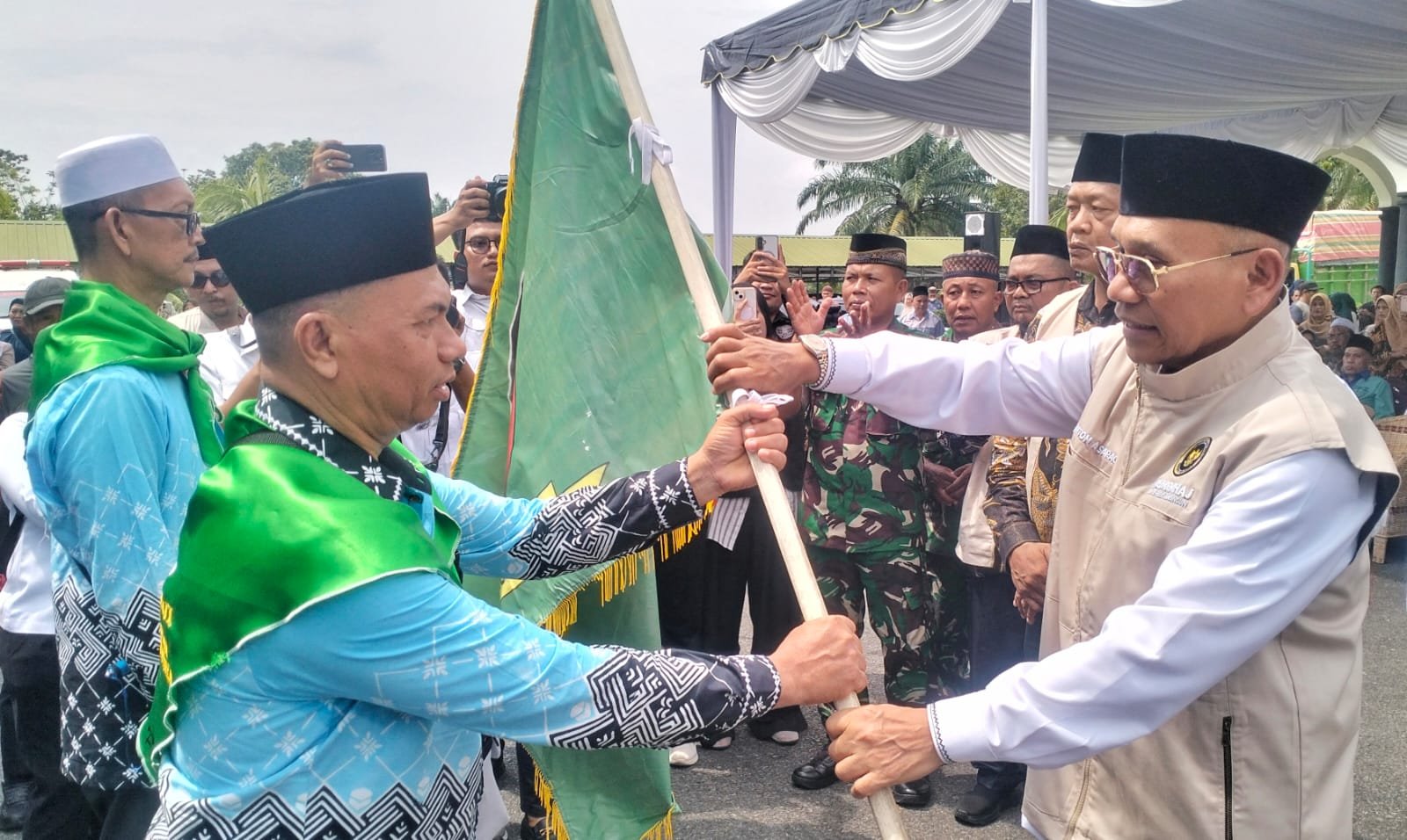 Bupati Simalungun saat penyerahan pataka Habonaron Do Bona kepada ketua rombongan sebagai doa restu agar perjalanan jamaah selamat dan lancar.