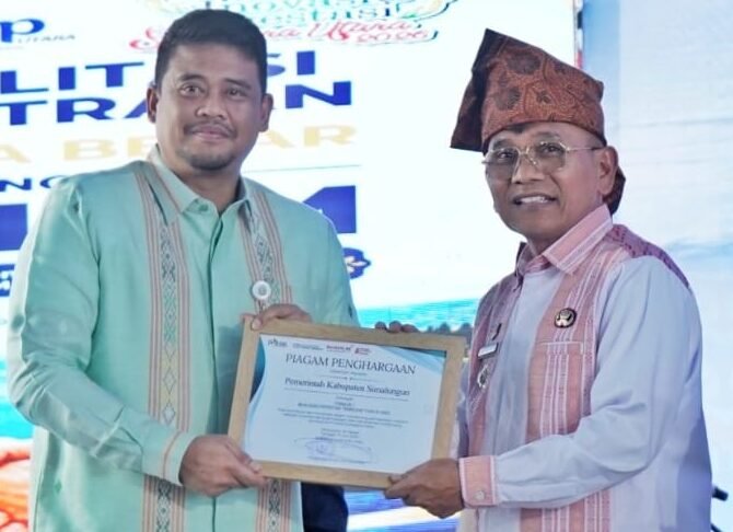 Gubsu M.Bobby Afif Nasution serahkan Piagam penghargaan kepada Bupati Simalungun, DR. H. Anton Achmad Saragih.