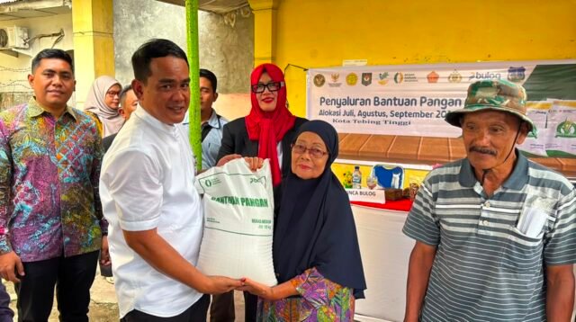 Pemimpin Wilayah Bulog Sumut, Budi Cahyanto saat memberikan bantuan pangan kepada seorang ibu di Tebing Tingginya.