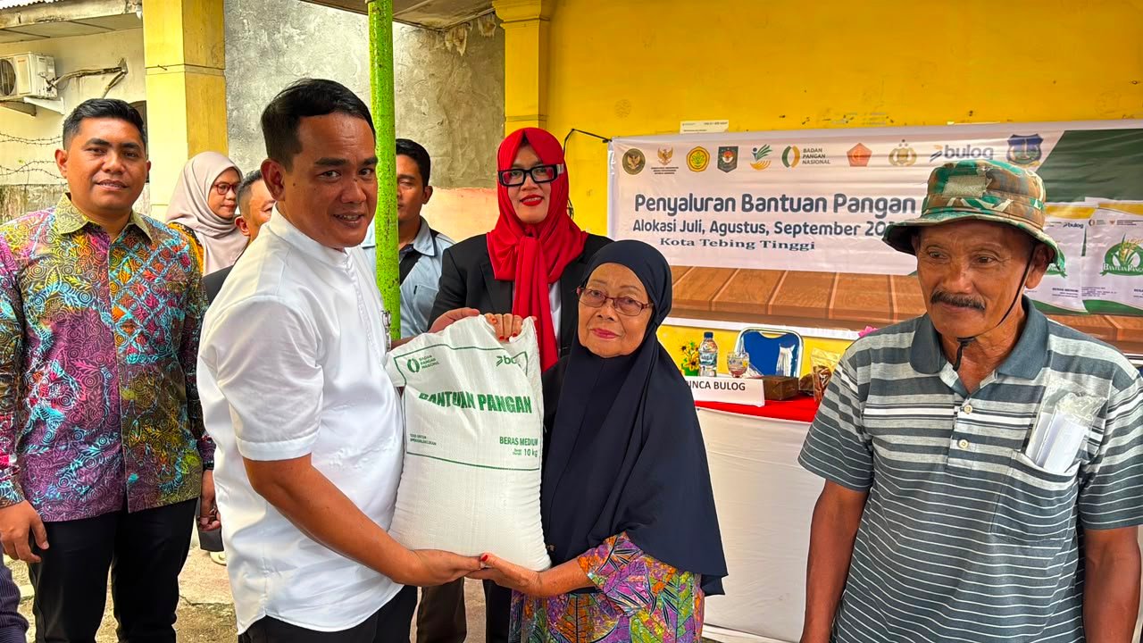 Pemimpin Wilayah Bulog Sumut, Budi Cahyanto saat memberikan bantuan pangan kepada seorang ibu di Tebing Tingginya.