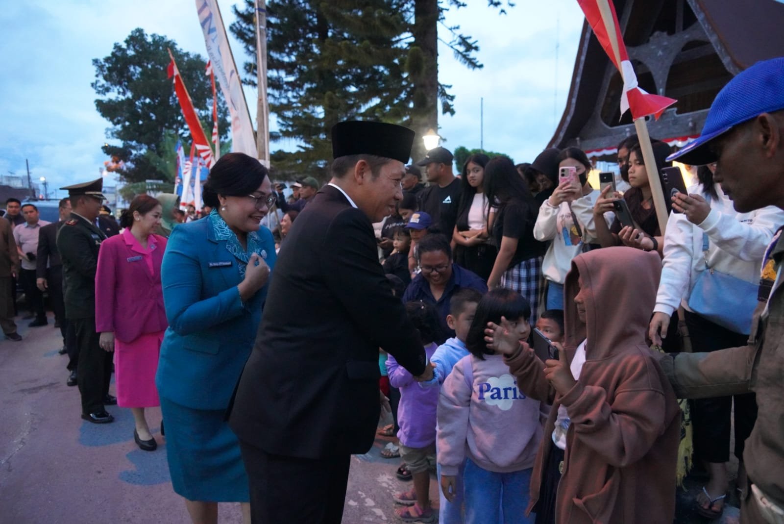 Bupati Taput dan nyonya br Purba menyalami warga jelang pawai obor di jalan Sisingamangaraja Tarutung.