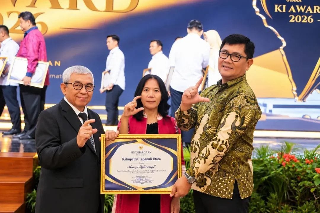Kadis Kominfo Donna Situmeang bersama Sekda Taput saat menerima penghargaan.
