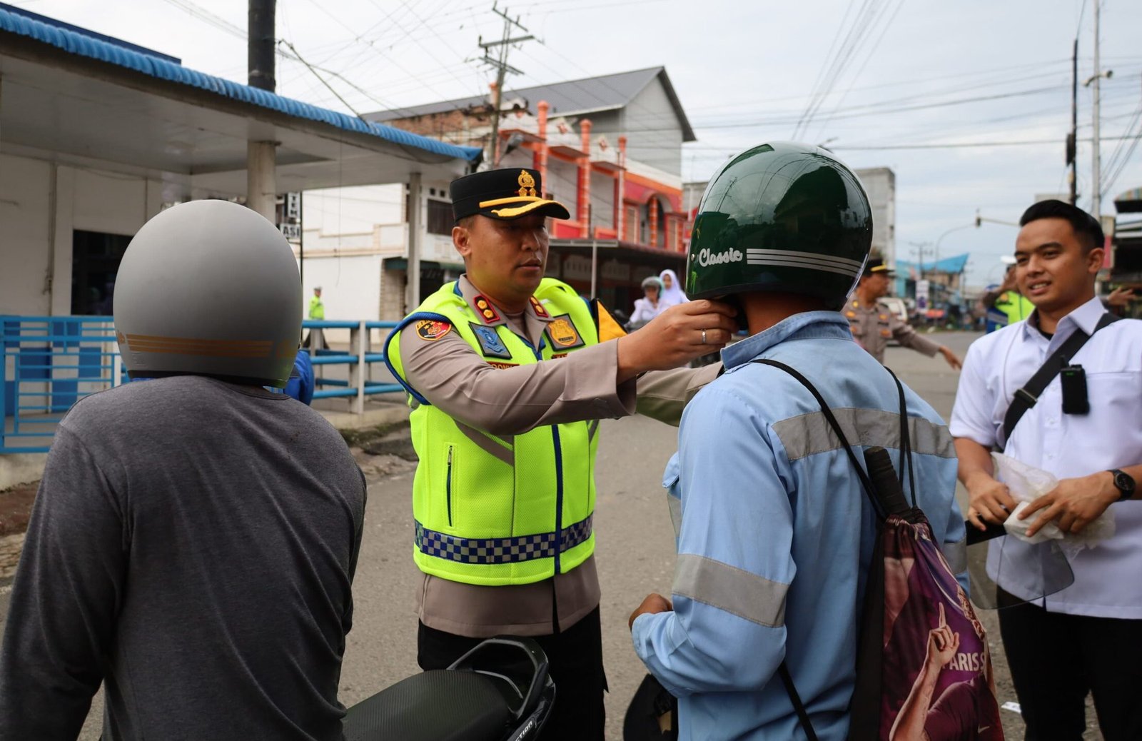 Tampak kapolres BB sedang mengenakan helm pada salah seorang pengendara pada giat Strong Point pagi dirawan macet